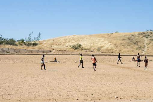 Young men playing football on the Samora Machel Soccer Field at Katutura Township near Windhoek in Khomas Region, Namibia. Samora Machel was the first President of Mozambique from its independence in 1975.