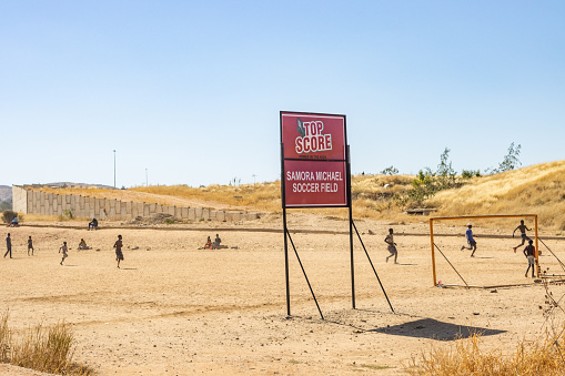 Namibian people playing soccer on the Samora Machel Soccer Field at Katutura Township near Windhoek in Khomas Region, Namibia. Samora Machel was the first President of Mozambique from its independence in 1975.