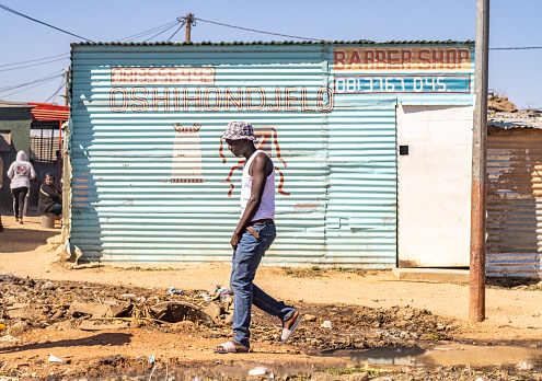 A man outside a Barber Shop at Katutura Township near Windhoek in Khomas Region, Namibia