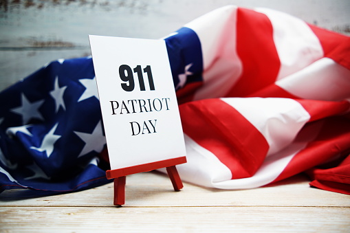 911 Patriot Day text and American flag on wooden background