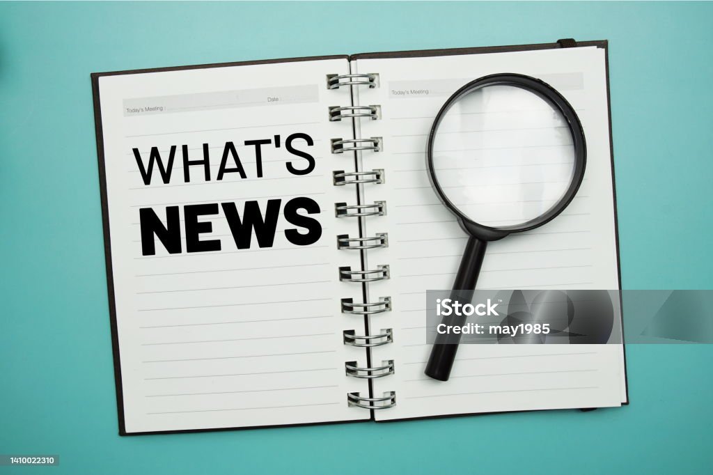 Whats News text on notepad and magnifying glass on blue background Blue Stock Photo