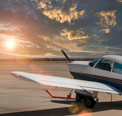 small airplane parked on the airfield at sunset