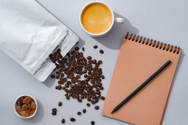 istock Cup of coffee with notebook on gray background top view 1410024339