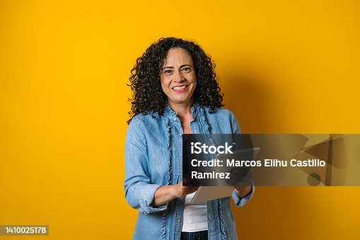 istock hispanic adult business woman portrait on yellow background in Mexico Latin America 1410025178