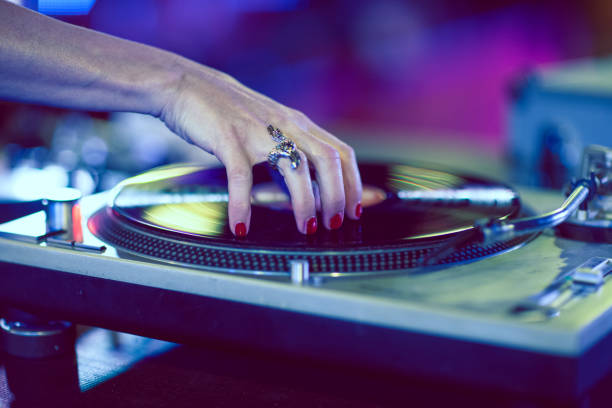 Detail of a woman's hand scratching a classic vinyl record in a nightclub. Detail of a woman's hand scratching a classic vinyl record in a nightclub. digital jukebox stock pictures, royalty-free photos & images