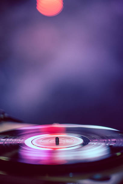 Old gramophone with Vynil disc playing music, colorful background