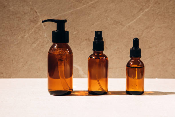 istock Clear amber bottle with natural cosmetics on a beige stone background 1410032821