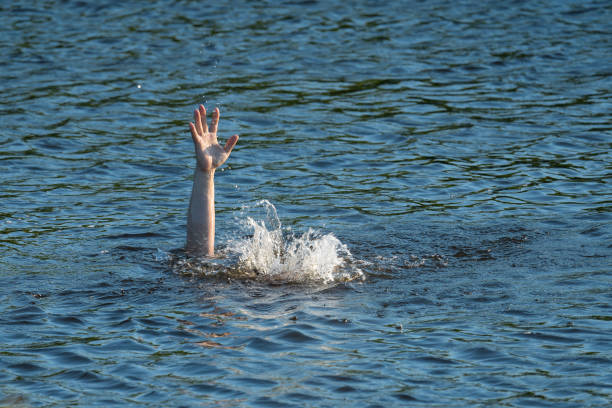 istock a man's hand above the surface of the water in the river, saving drowning 1410037596