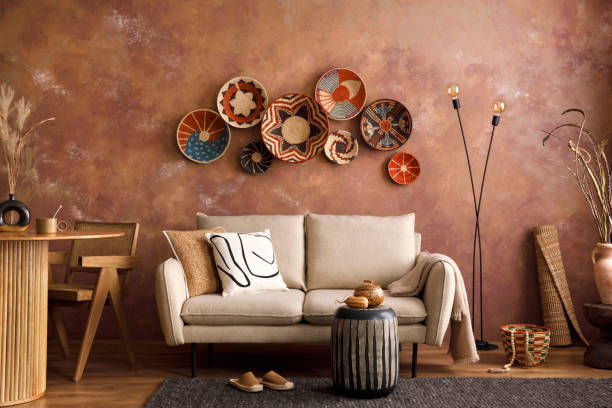 istock The stylish boho compostion at living room interior with design beige sofa, coffee table, table, wicker baskets and personal accessories. Brown and white pillows and plaid. Cozy apartment. Template. 1410040608