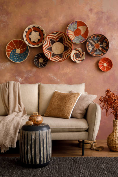 istock The stylish boho compostion at living room interior with design beige sofa, coffee table, wicker baskets and elegant personal accessories. Brown and white pillows and plaid. Cozy apartment. Home decor 1410040613