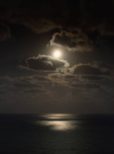 istock Moon over the night sea among the clouds 1410040616
