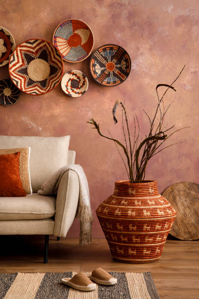 istock The stylish boho compostion at living room interior with design beige sofa, coffee table, wicker baskets and elegant personal accessories. Brown and white pillows and plaid. Cozy apartment Home decor 1410040623