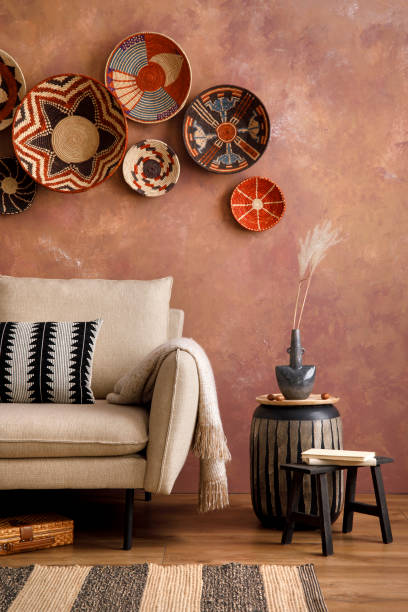 istock The stylish boho compostion at living room interior with design beige sofa, coffee table, wicker baskets and elegant personal accessories. Brown and white pillows and plaid. Cozy apartment. Home decor 1410040634
