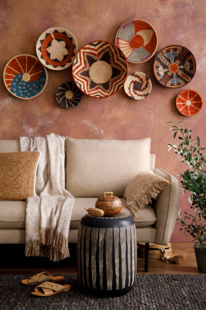 istock The stylish boho compostion at living room interior with design beige sofa, coffee table, wicker baskets and elegant personal accessories. Brown and white pillows and plaid. Cozy apartment. Home decor. 1410041204