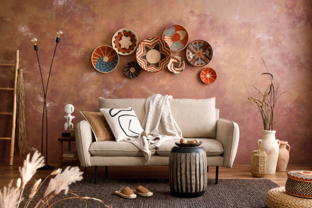 istock The stylish boho compostion at living room interior with design beige sofa, coffee table, wicker baskets and elegant personal accessories. Brown and white pillows and plaid. Cozy apartment Home decor 1410041221