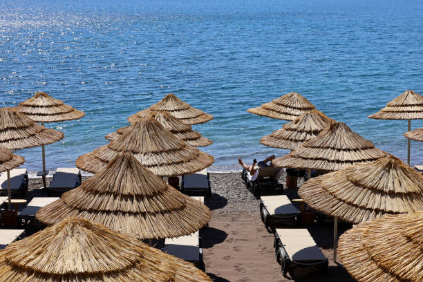 istock Pebble beach with wicker parasols and deck chairs 1410041256