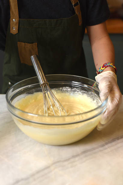 istock A hand in rubber glove stirring dough for a cake 1410041976