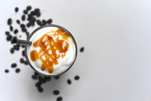 Ice caramel latte with coffee beans isolated on white background