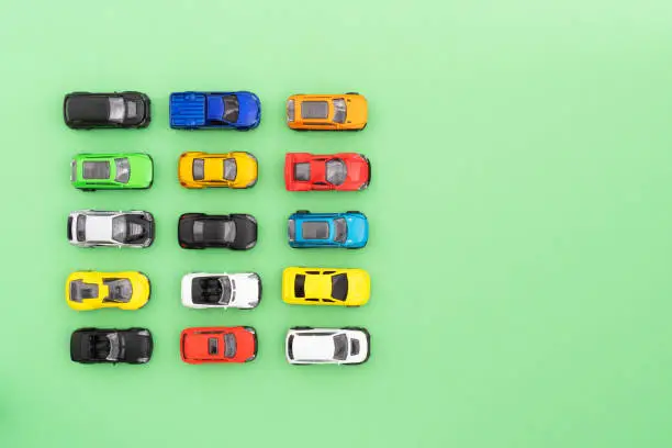 Photo of Set of colorful toy cars on green background.