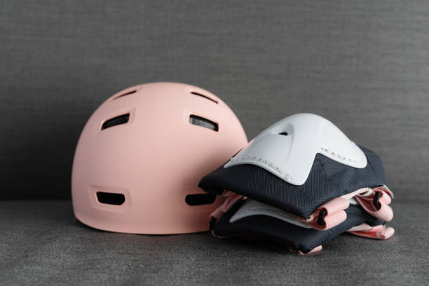 Pink helmet on dark grey background. Childs outdoors activity safety protection stock photo