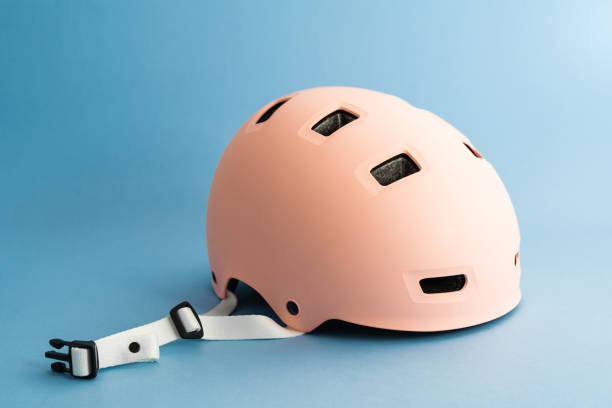 Pink helmet on blue background. Childs outdoors activity safety protection stock photo