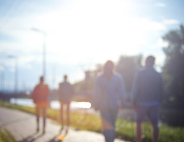 istock couples walking along sunny urban recreational zone. defocused 1410049757