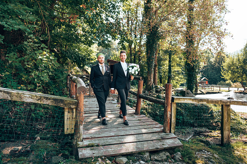 gay couple walking together after the bride