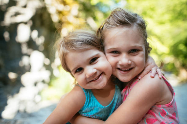 istock Two girls hugging, smiling and looking at camera 1410055119
