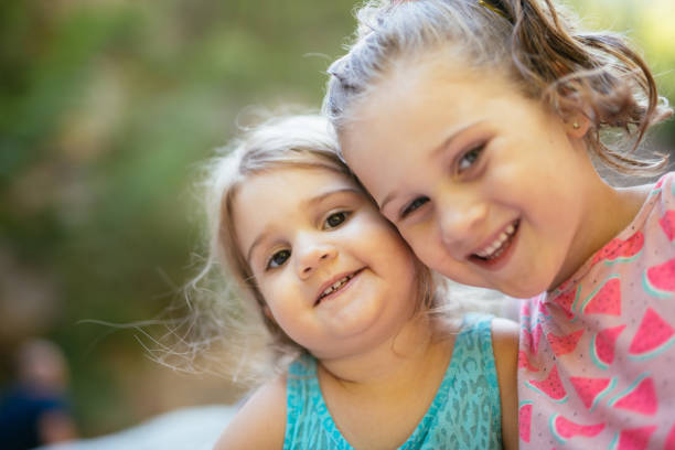 Two little sisters in the park on a sunny autumn day. family time.