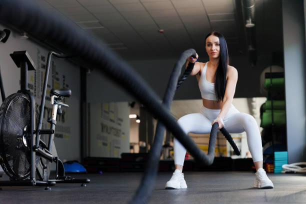 istock Woman doing battle rope workout at gym 1410055859