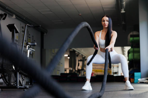 istock Woman doing battle rope workout at gym 1410055881