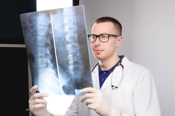 istock surgeon examines x-ray. spinal x-ray. health problems. nurse checking x-ray in hospital. An experienced male doctor interprets an x-ray. man looks. 1410056087