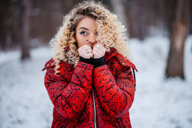 Teenaged girl jumpin in snow. Flying with hands outstretched. Towards camera.
