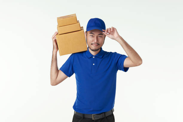 przystojny azjatycki kurier trzymający paczkę paczkową odizolowaną na białym tle, kurier dostawy i koncepcję usługi wysyłkowej. - portage zdjęcia i obrazy z banku zdjęć