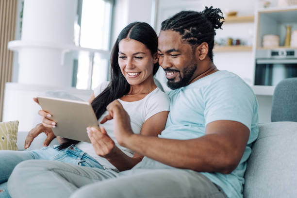 istock Smiling young couple using digital tablet at home. 1410057074