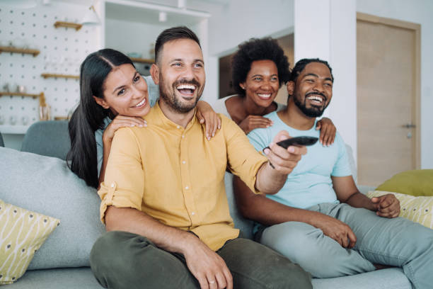 istock Cheerful friends watching TV at home. 1410057075