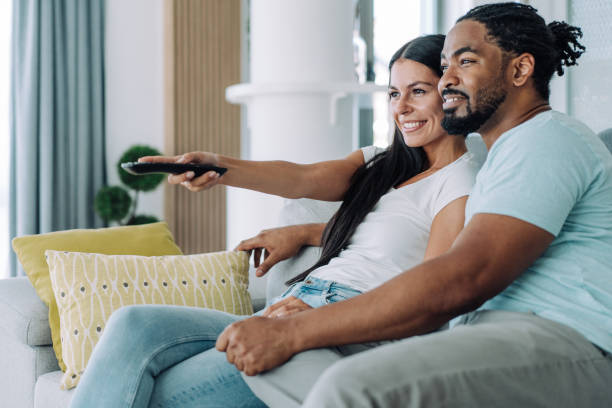 istock Cute young couple cuddling while watching tv. 1410057076