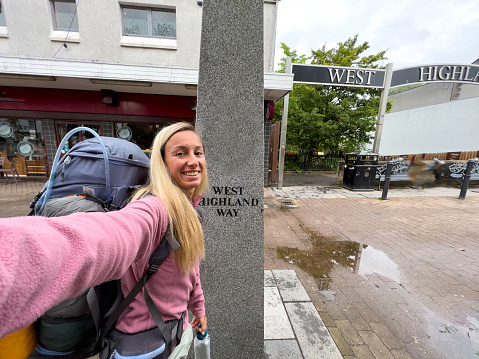 Young woman backpacking on the West Highland way in Scotland. She takes selfies on the way.