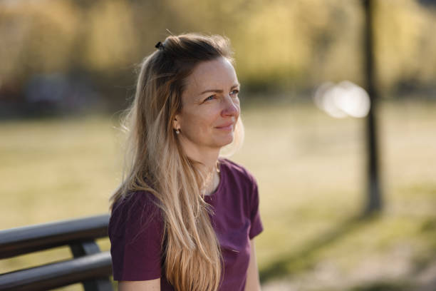istock Woman sitting on the bench in public park 1410061079