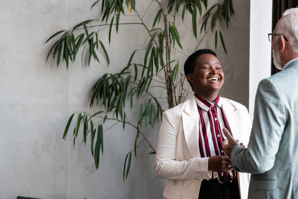istock Young businesswoman laughing while her CEO is sharing a story with her 1410061237