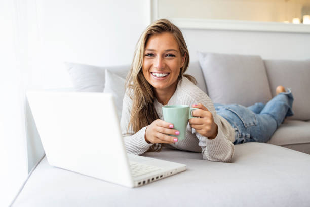 istock Woman using laptop at home, looking at screen 1410061382