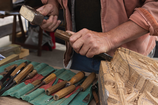 a man makes products from a tree with his own hands and with a tool close-up of a hand a tree