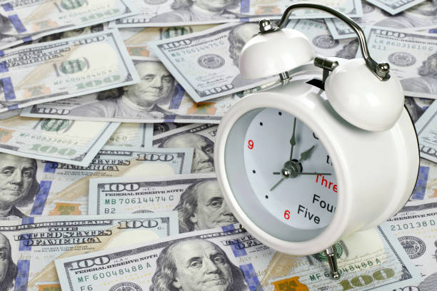 istock Time is money concept with clock and USA dollars 1410063996
