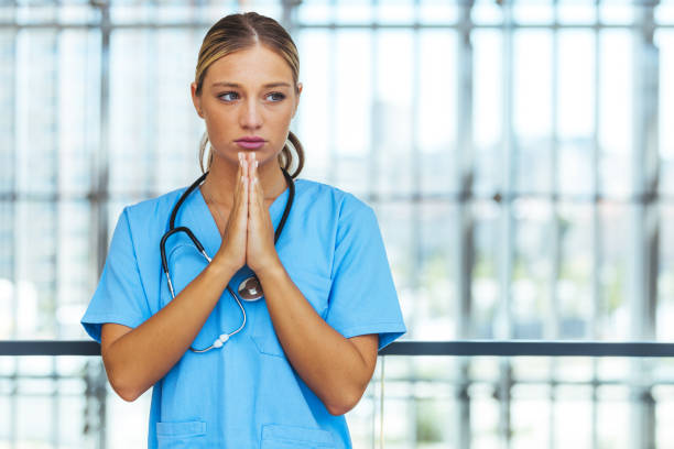 istock Prayerful Stressed Female Doctor or Nurse On Break 1410064299