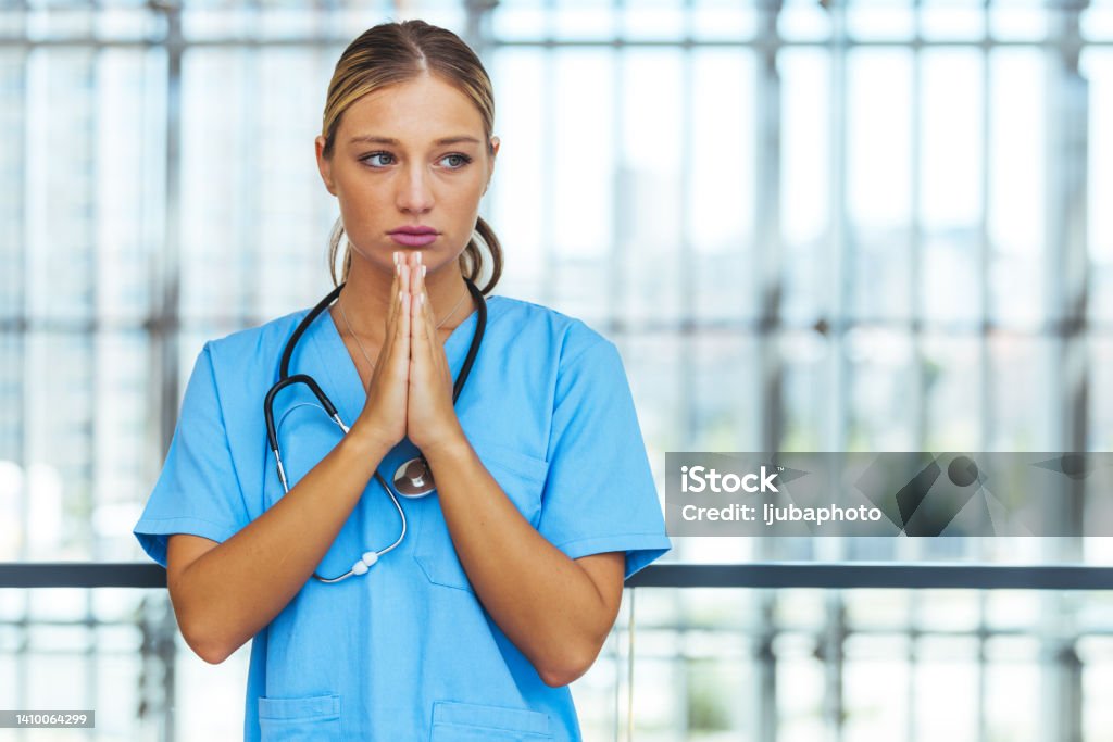 Prayerful Stressed Female Doctor or Nurse On Break 20-24 Years Stock Photo