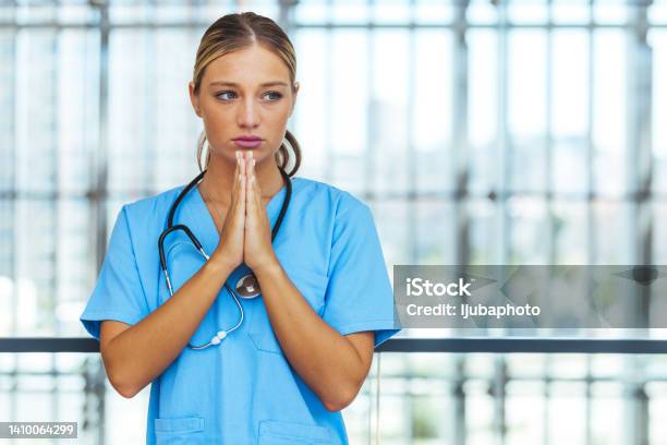 Prayerful Stressed Female Doctor Or Nurse On Break Stock Photo - Download Image Now - 20-24 Years, Adult, Adults Only