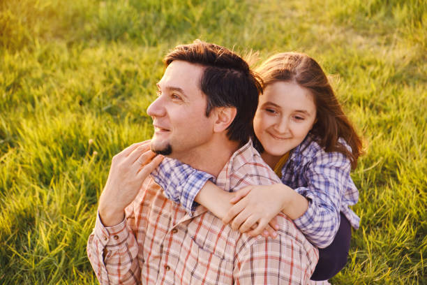 istock Smiling little girl hugging her father outside 1410065632