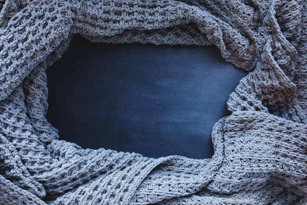 istock Knit Grey Blanket over Dark Ombre Wood Background 1410067822