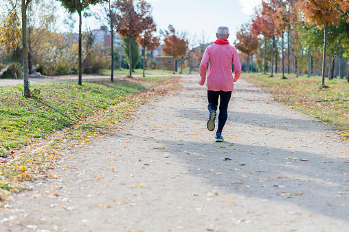 Rear View Of a Senior Man Running Against Sky At Park