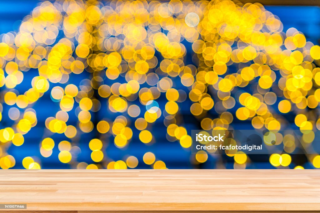 Empty wooden table with defocused yellow lights background. Copy space Backgrounds:Empty wooden table with defocused yellow Christmas lights background. Ideal for product display on top of the table. Abstract Stock Photo
